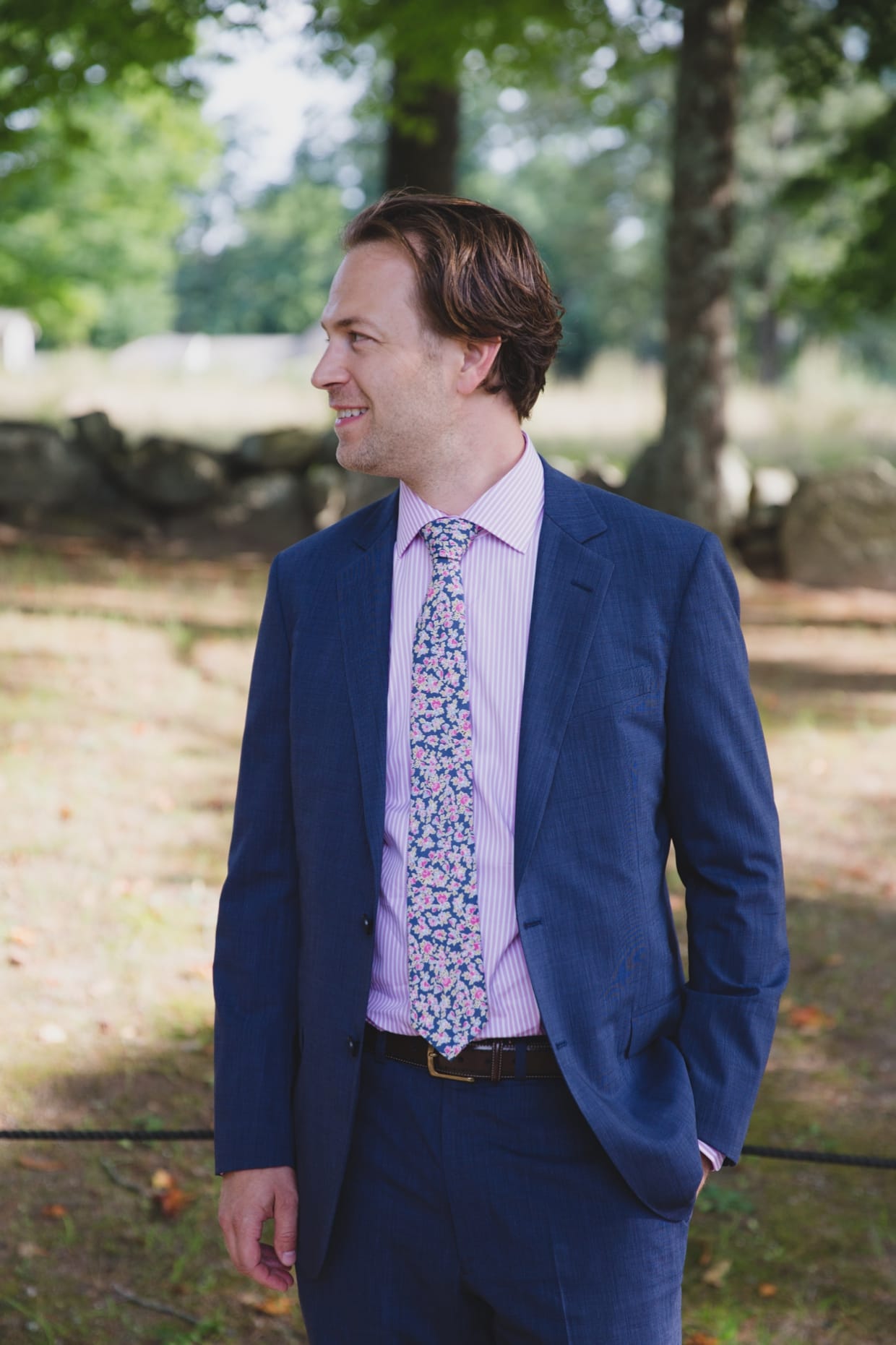 A groom smiles as he sees his bride walk towards him during the first look before their backyard wedding in Massachusetts