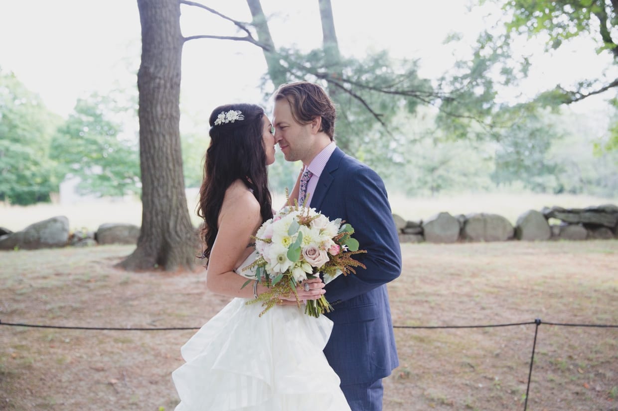 A sweet portrait of a bride and groom kissing during the first look before their backyard wedding in Massachusetts