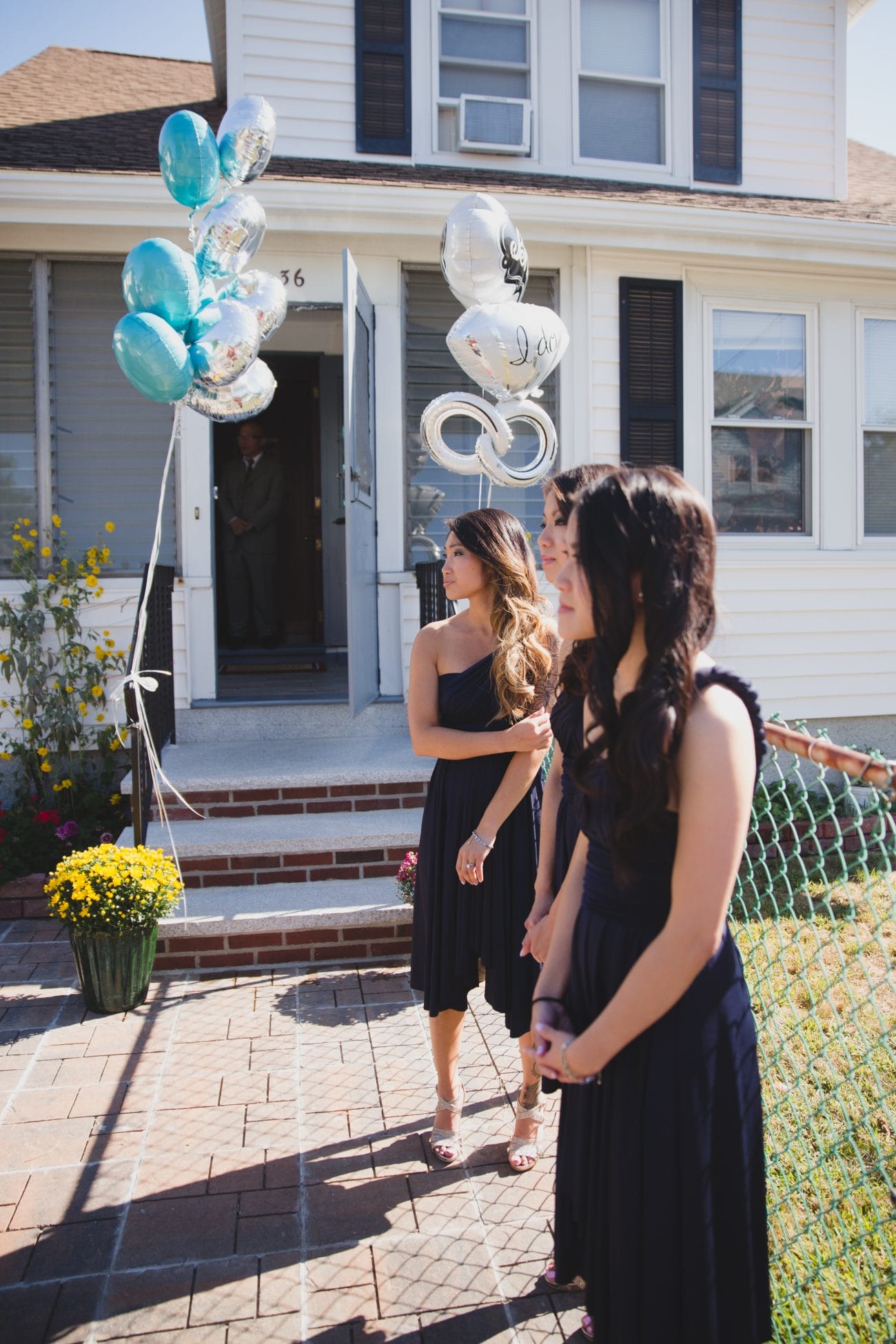 Bridesmaid stand in front of the bride's family home in preparation for their vietnamese tea ceremony in boston