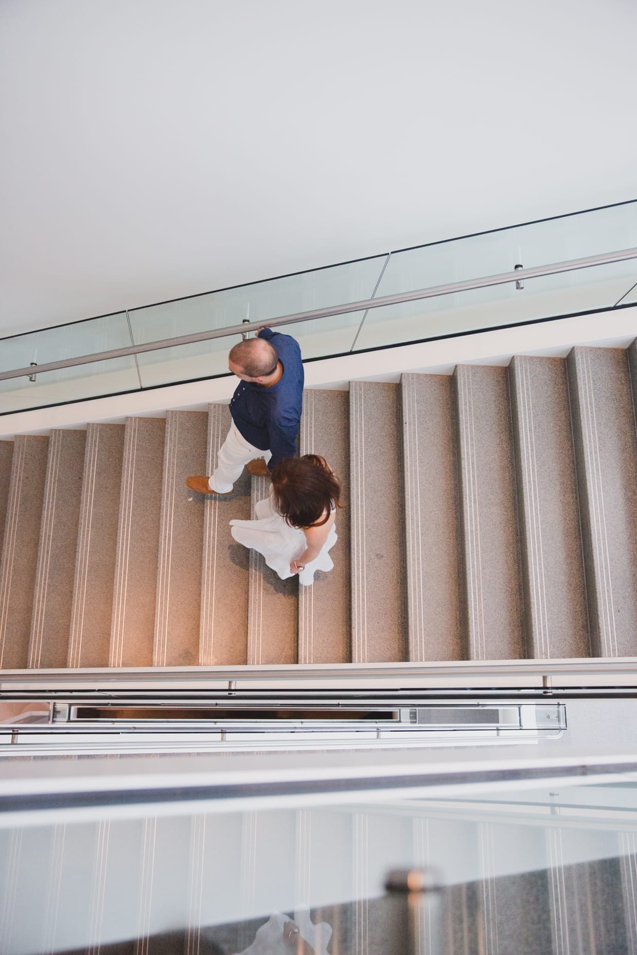 A unique and modern photograph of a couple walking down the stairs of the Museum of Fine Arts during their Boston Engagement Session