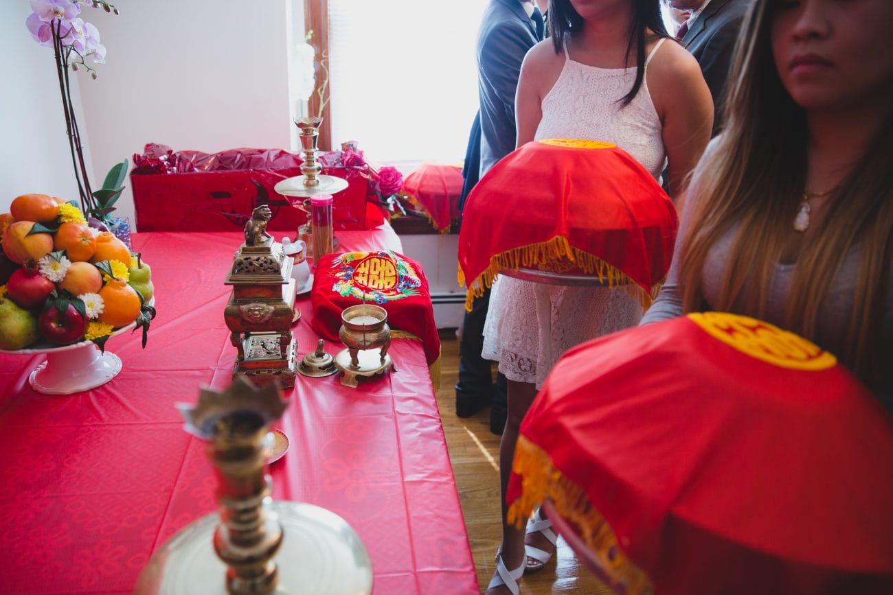 A documentary style photograph of bridesmaids bringing in gifts from a vietnamese tea ceremony in Boston