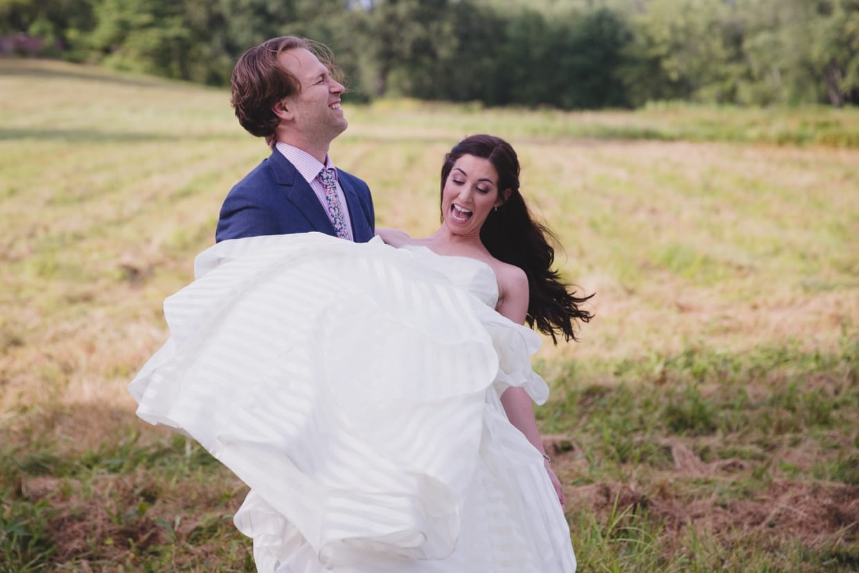 A funny portrait of a groom spinning his bride around before their backyard wedding in Massachusetts
