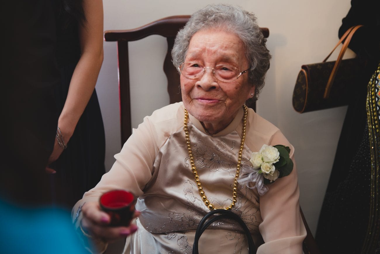 A beautiful documentary style photograph of a grandmother drinking tea and sharing a toast during a vietnamese tea ceremony in Boston