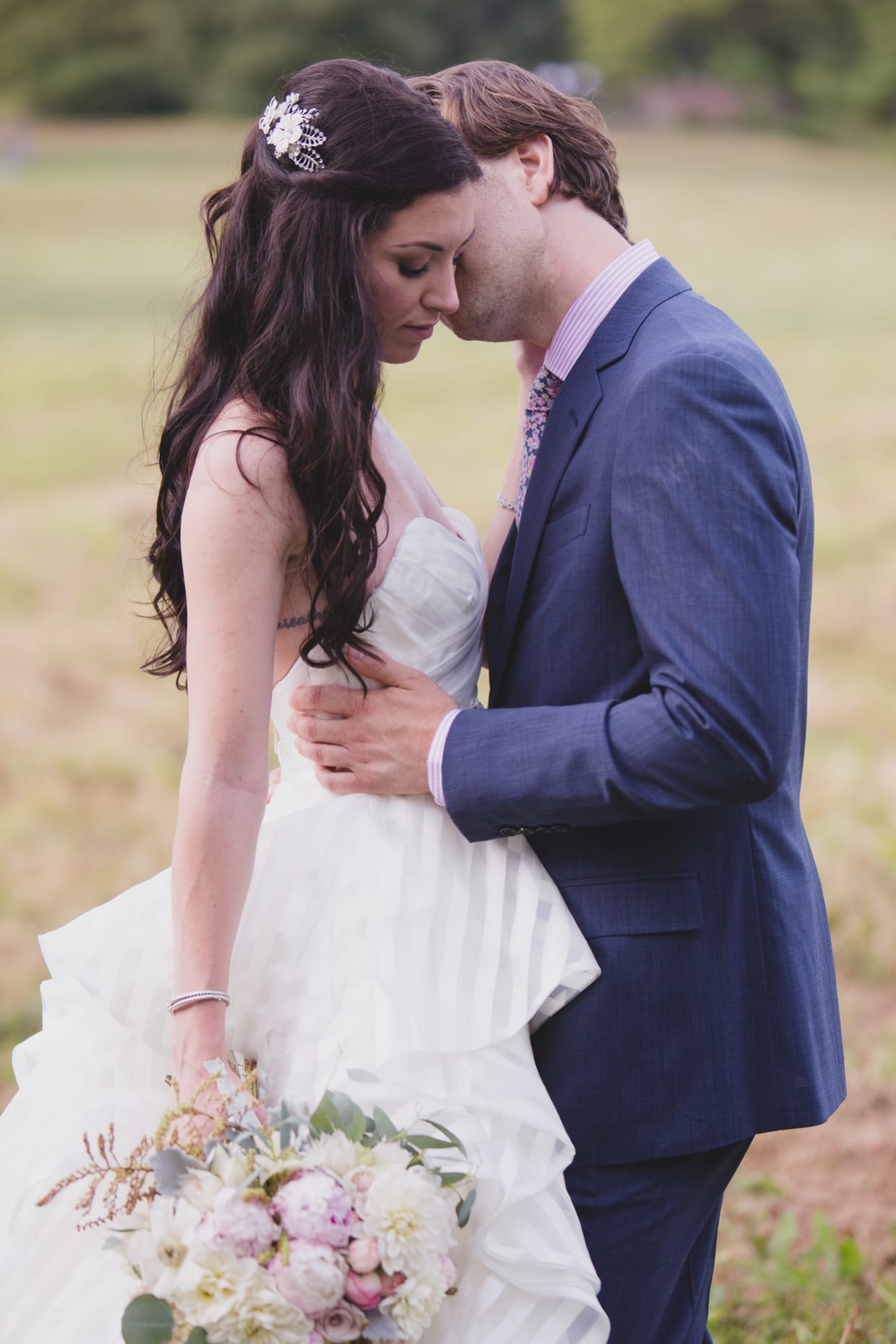 A sweet and natural wedding portrait during a first look at the Minute Man Park in Massachusetts