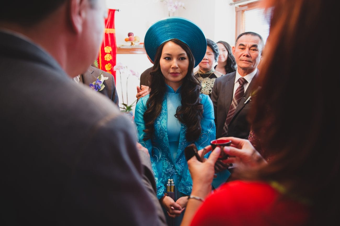 A documentary style photograph of a bride during her vietnamese tea ceremony in Boston