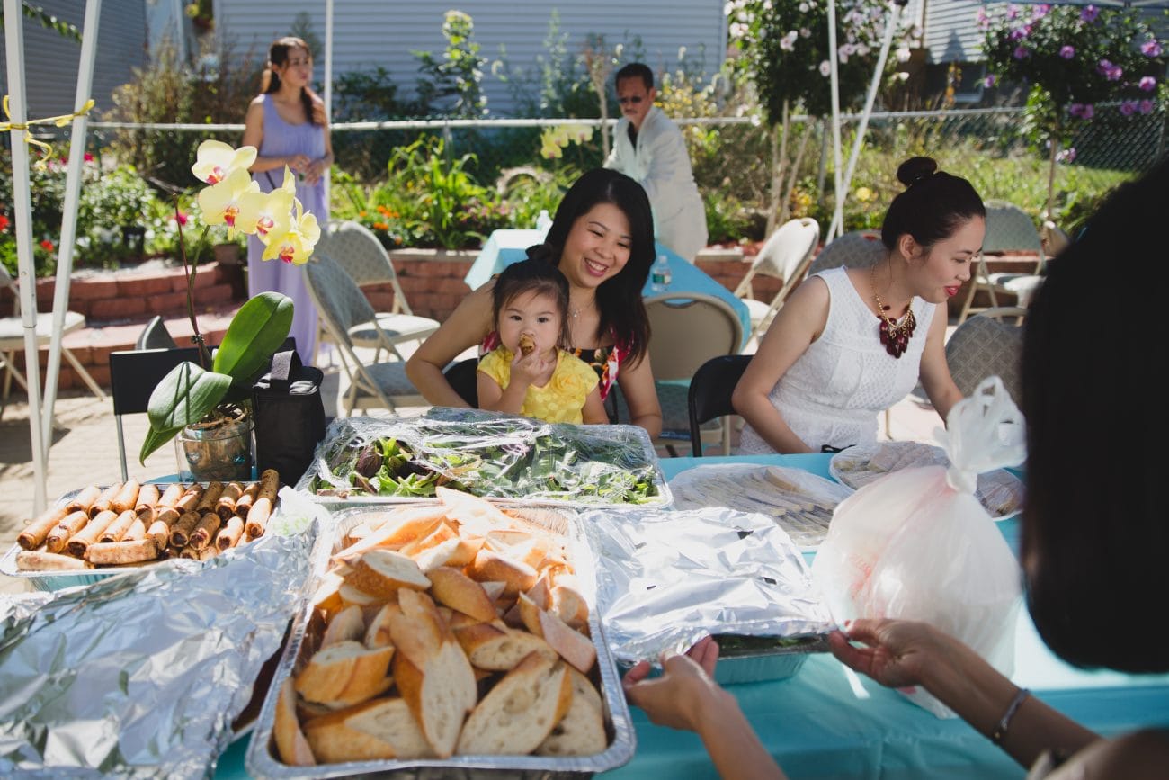 A documentary style photograph of a family preparing food for a vietnamese tea ceremony reception in Boston