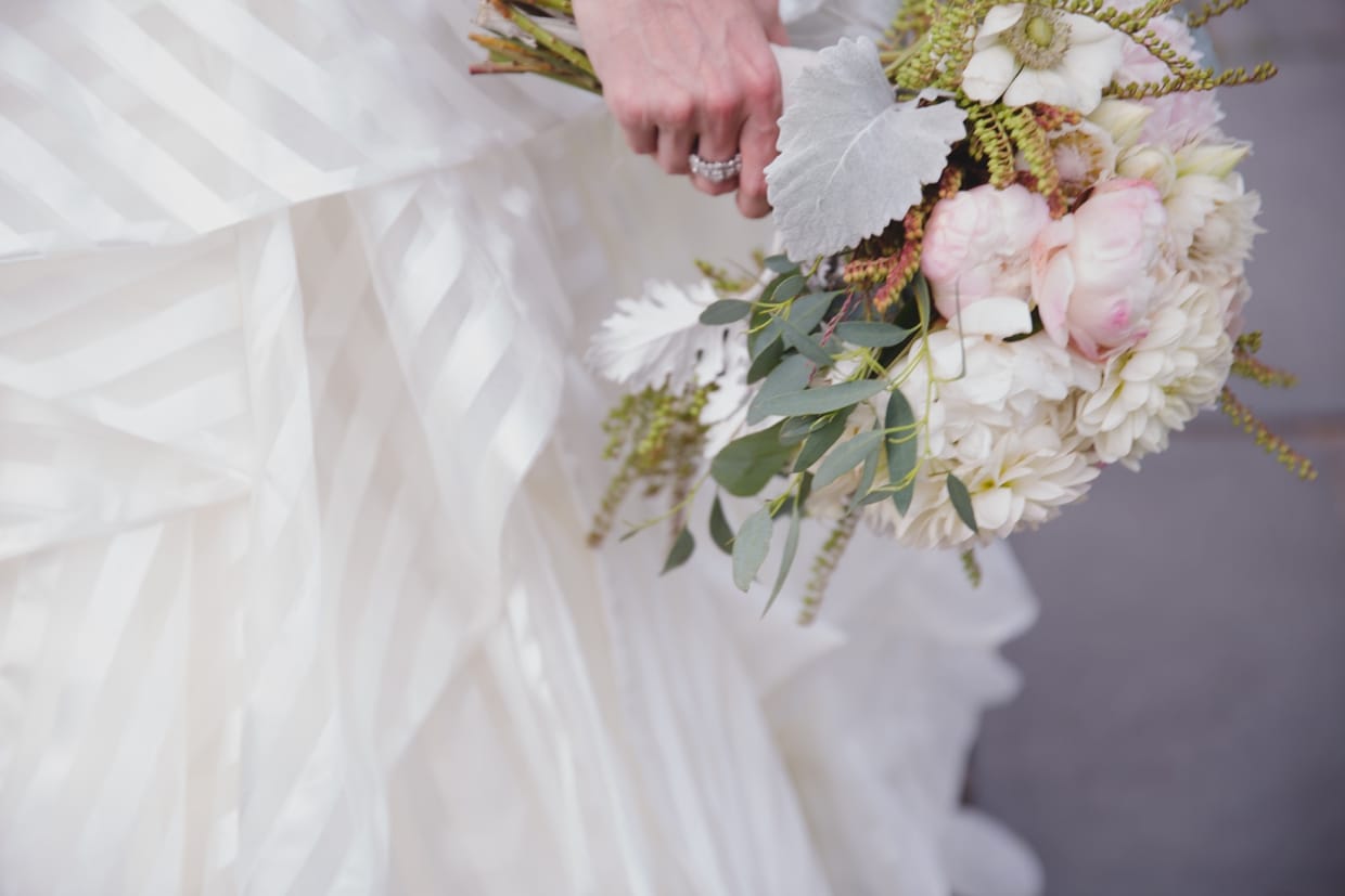 A detailed photograph of a bride holding her wedding bouquet created by Copper Penny in Massachusetts