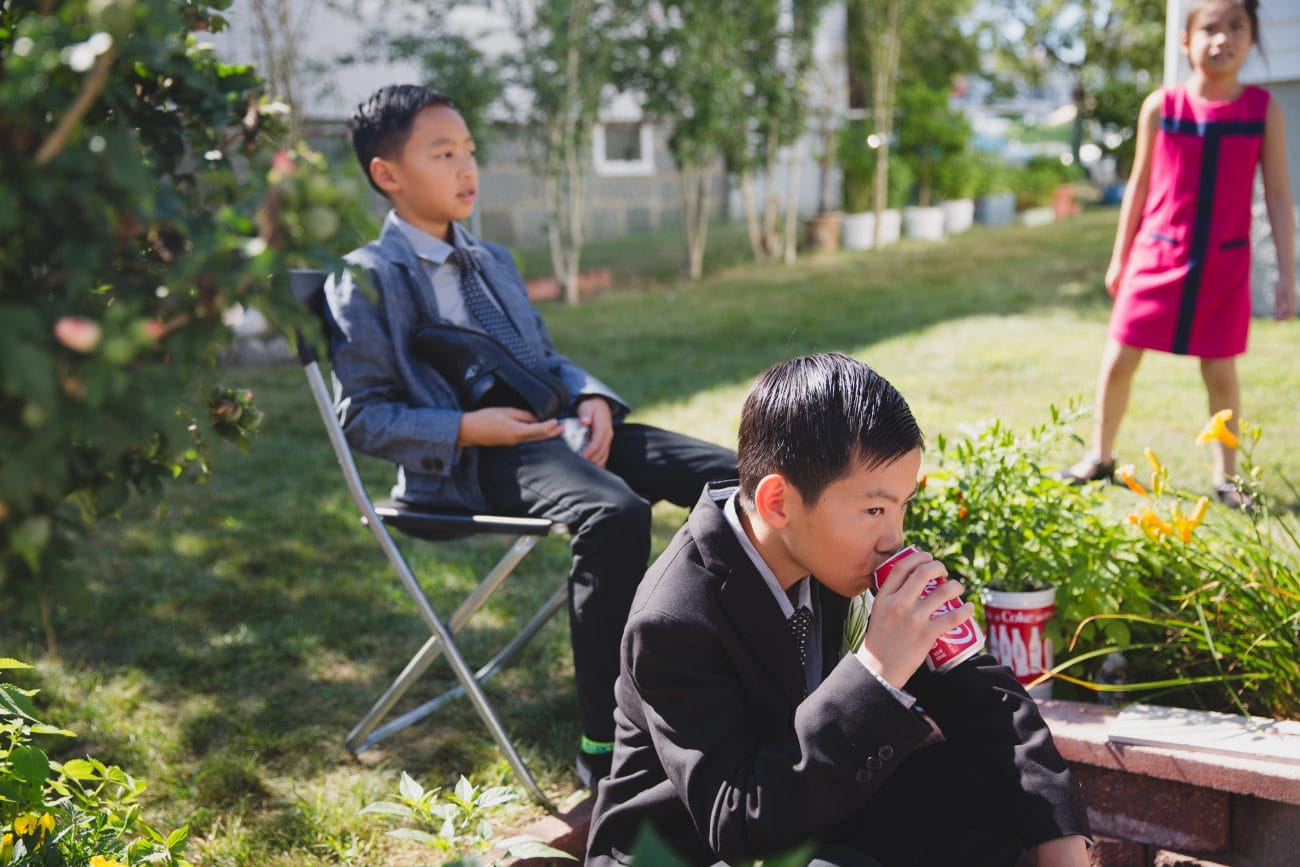 A candid photograph of kids playing and drinking coke after a vietnamese tea ceremony in Boston