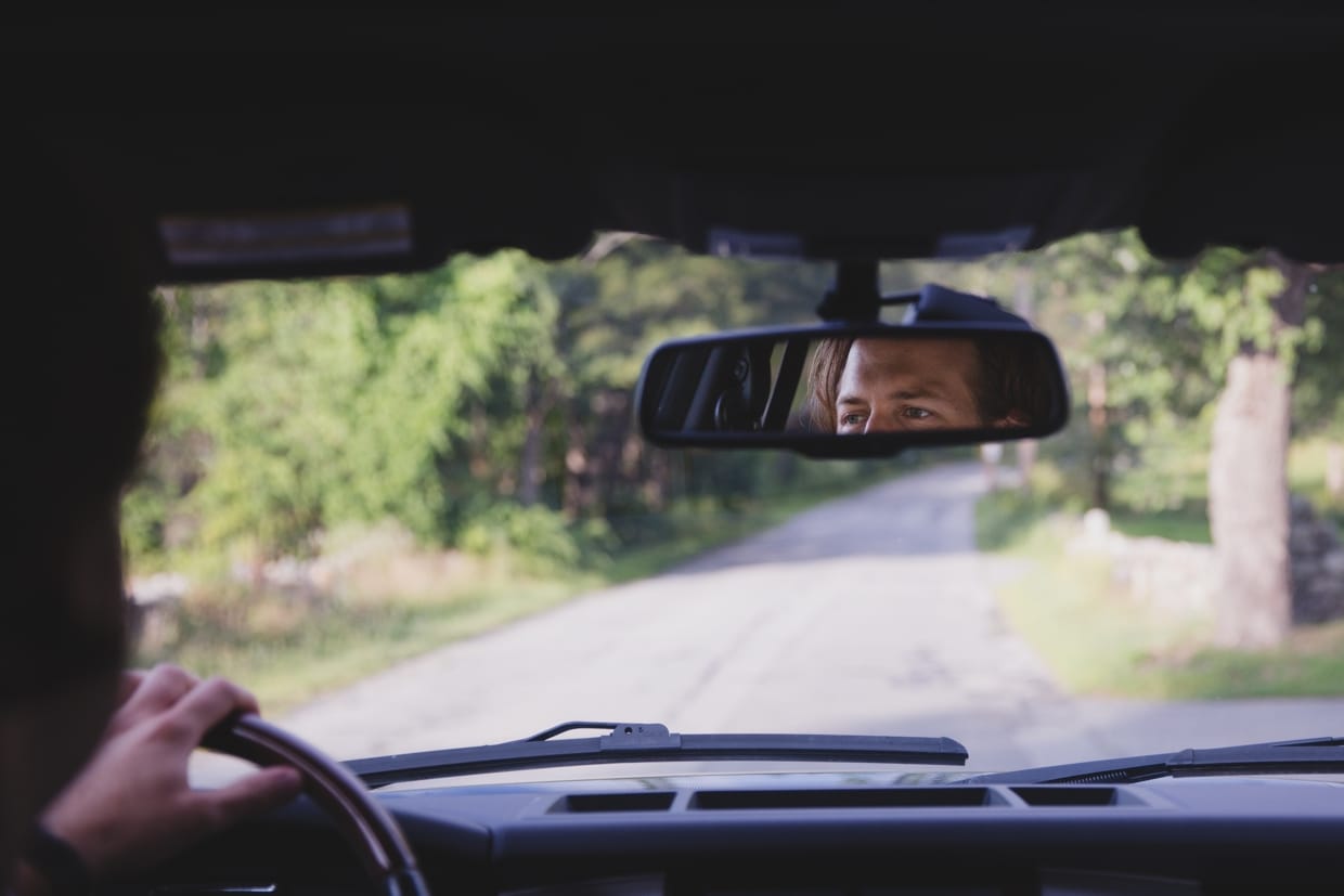 A documentary photograph of a groom driving to his backyard wedding in Massachusetts