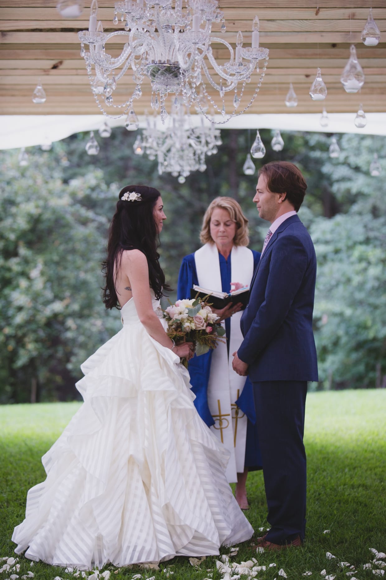 A bride and groom stand together at the top of the aisle during their backyard wedding ceremony in Massachusetts