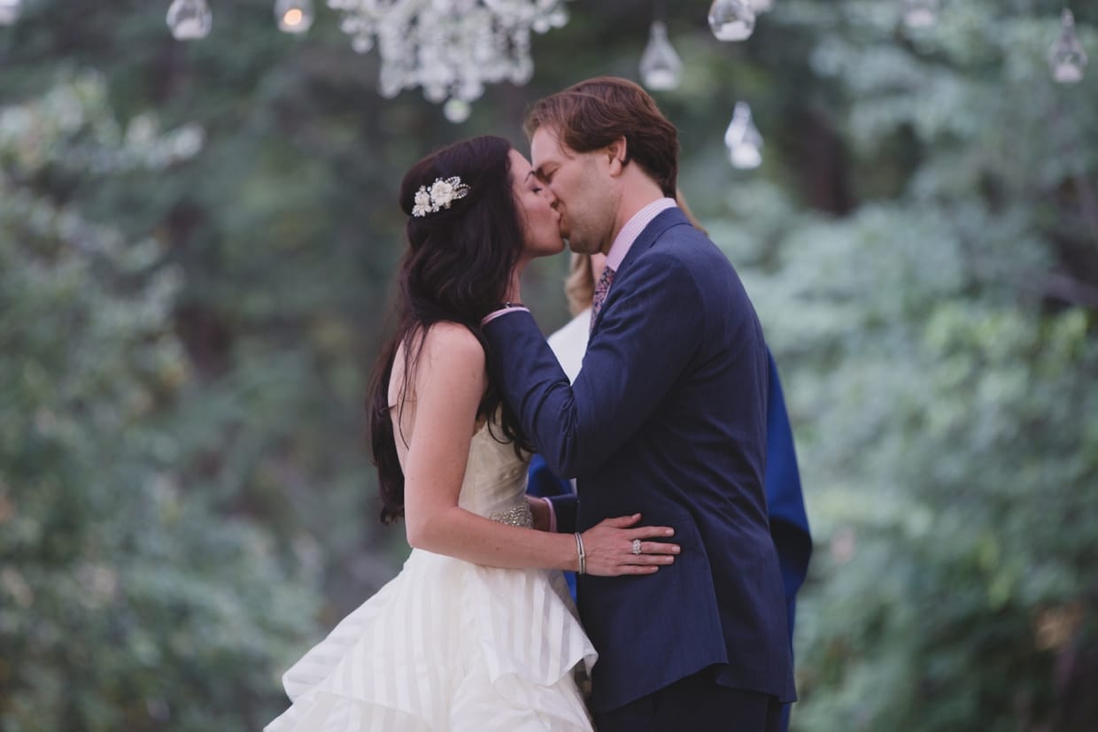 A bride and groom share their first kiss as husband and wife during their backyard wedding ceremony in Massachusetts