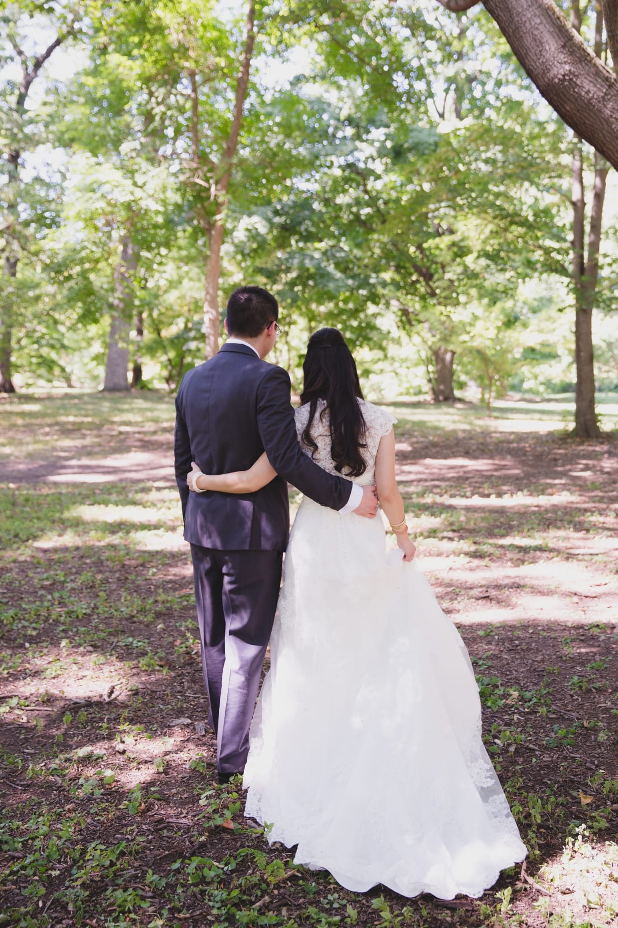 A romantic photograph of a couple walking through the Arnold Arboretum during their first look in Boston, Massachusetts