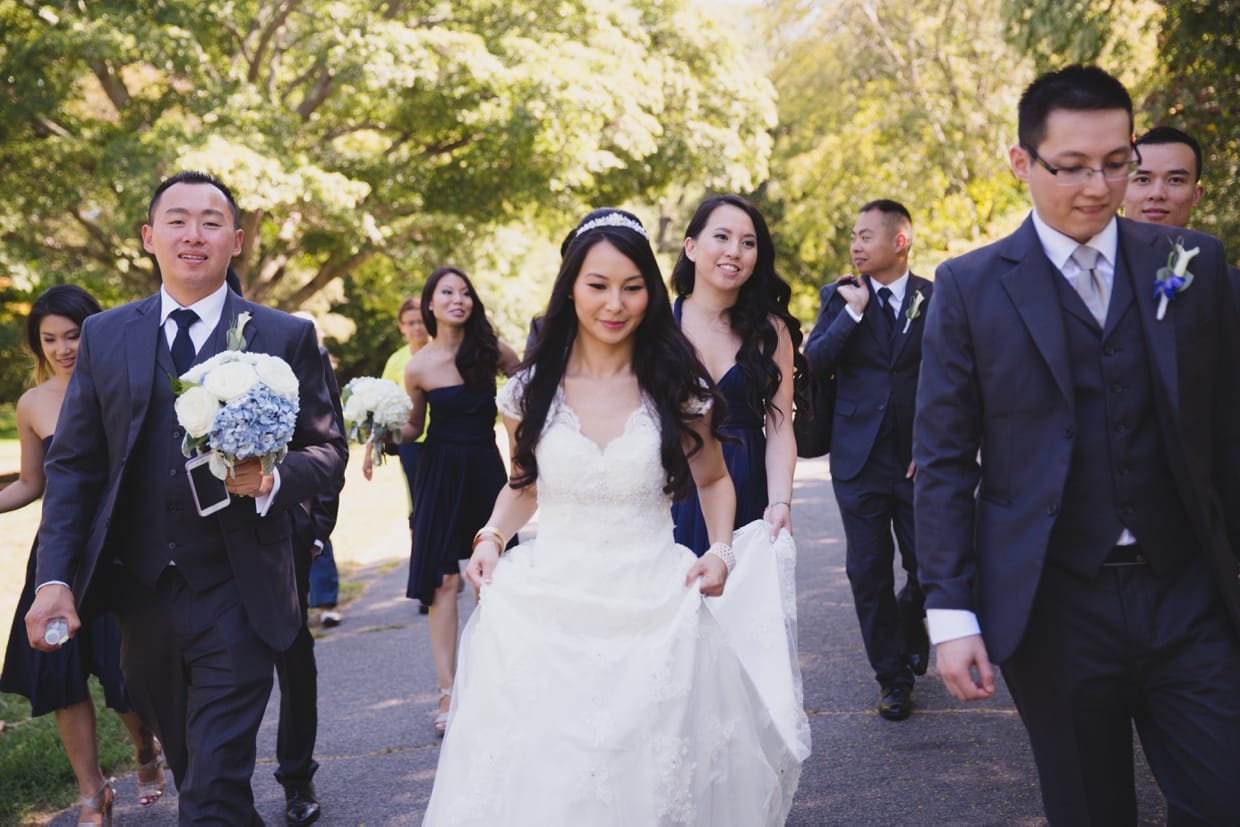 A candid photograph of a wedding party walking through the Arnold Arboretum before they head back to the Boston Marriott Hotel