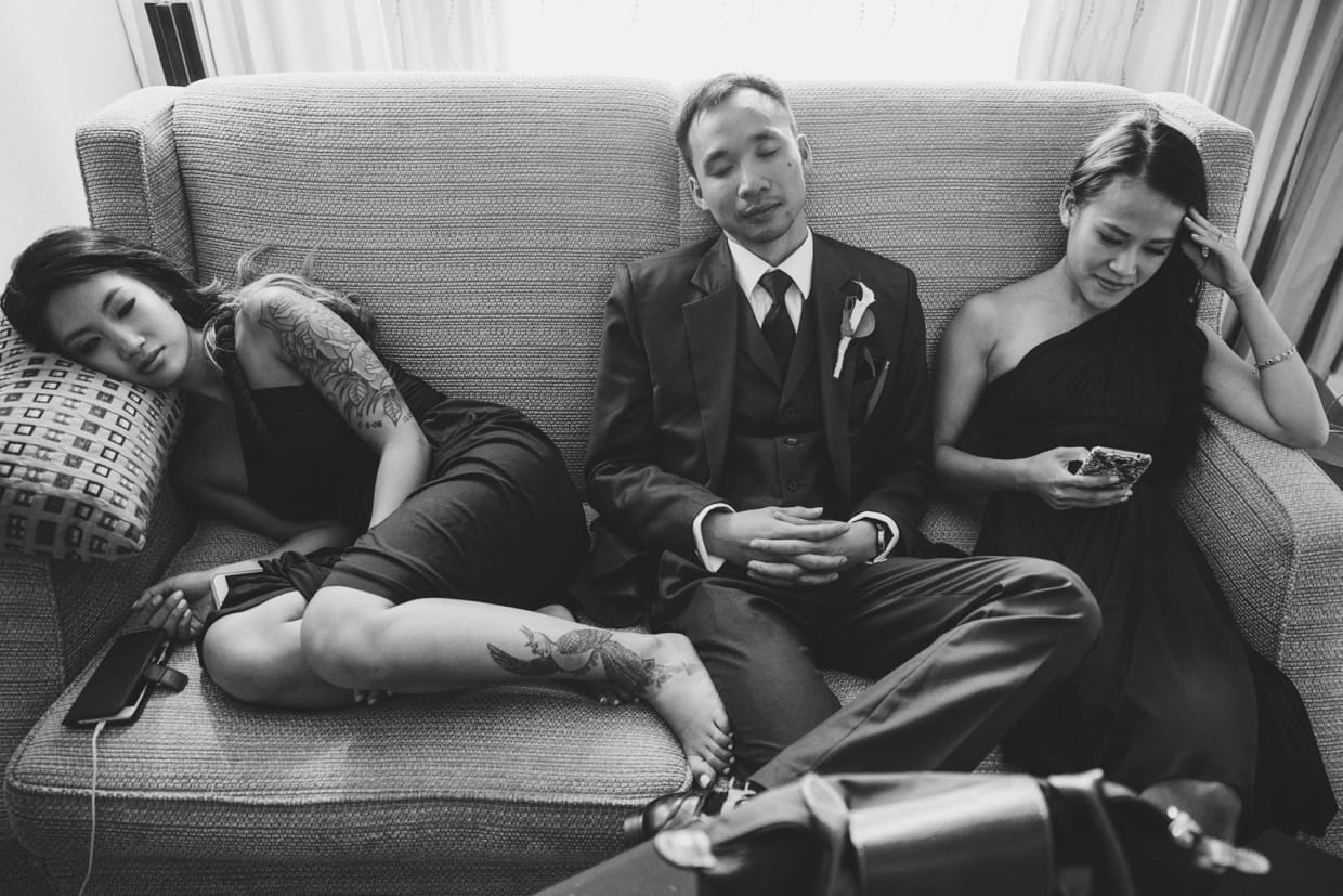 A documentary style photograph of the bridesmaids and groomsmen having a rest before the wedding ceremony at the Boston Marriott Hotel
