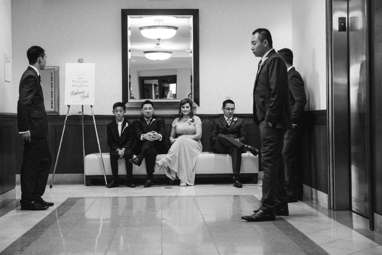 A documentary style photograph of a groom waiting for the wedding ceremony to start at the Boston Marriott Hotel