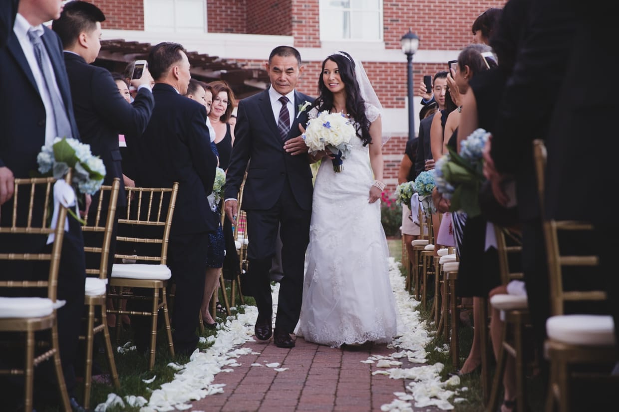 A beautiful photograph of a father walking his daughter up the aisle during her wedding ceremony at the Boston Marriott Hotel