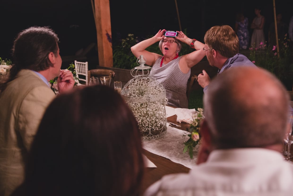 A candid photograph of wedding guests playing party games during a backyard wedding in Massachusetts
