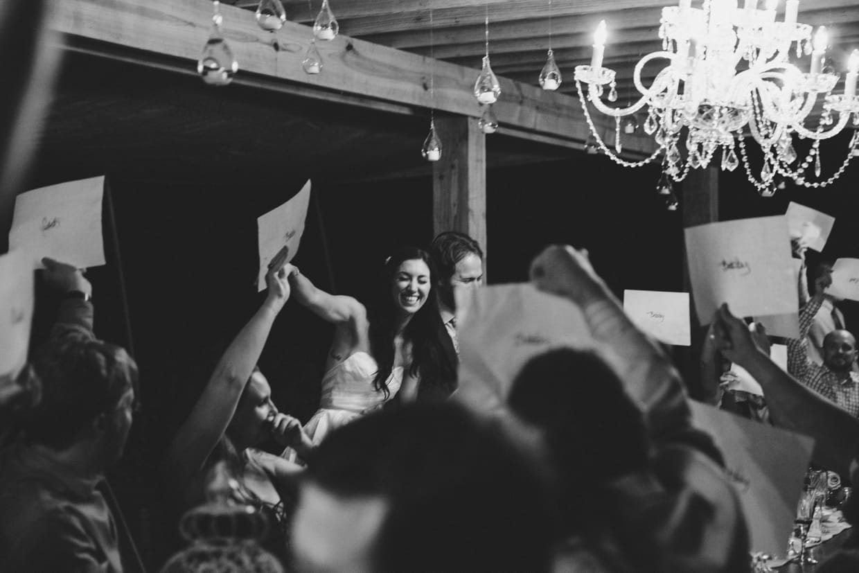 A fun and documentary style photograph of a bride and groom playing party games at their backyard wedding in Massachusetts