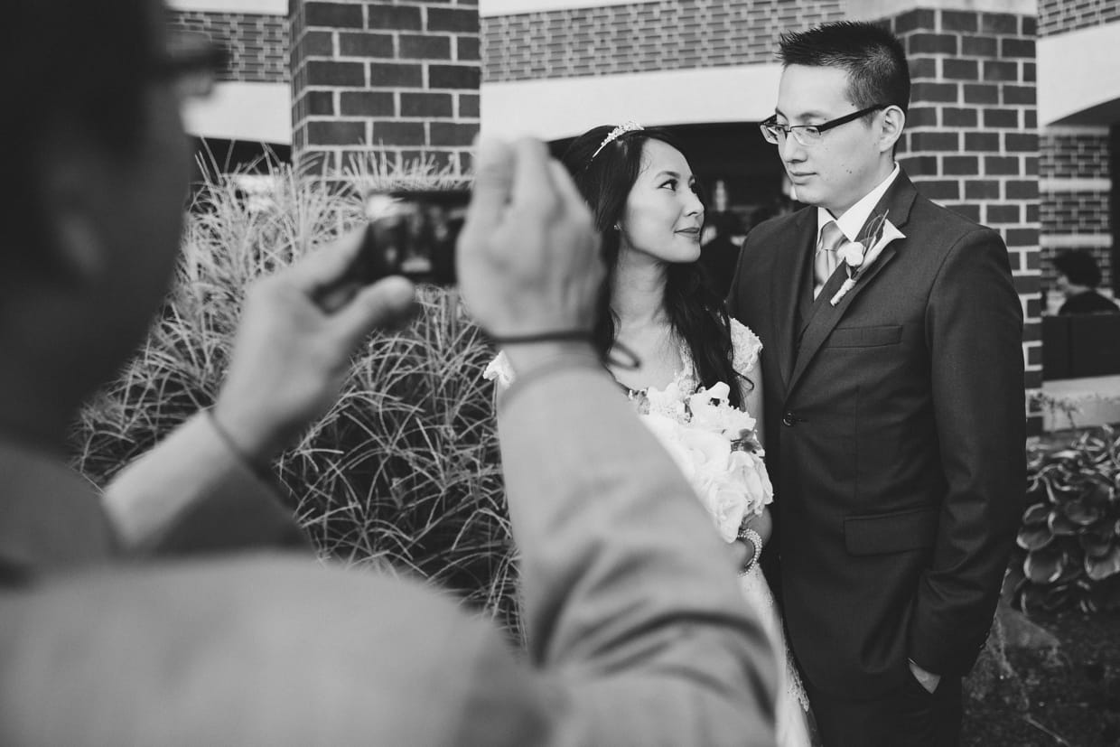 A documentary style photograph of a guest taking photographs of the bride and groom at the Boston Marriott Hotel