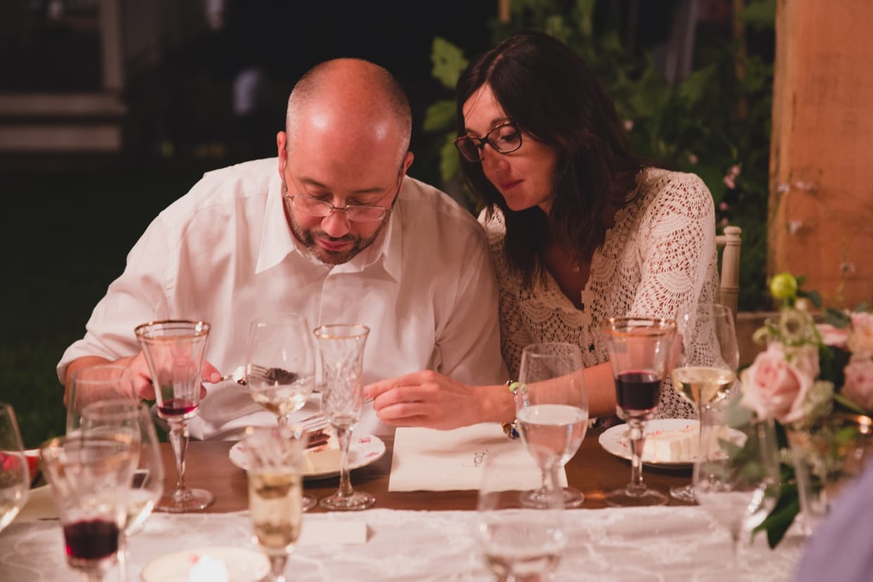 A candid photograph of a couple eating cake during a backyard wedding in Massachusetts