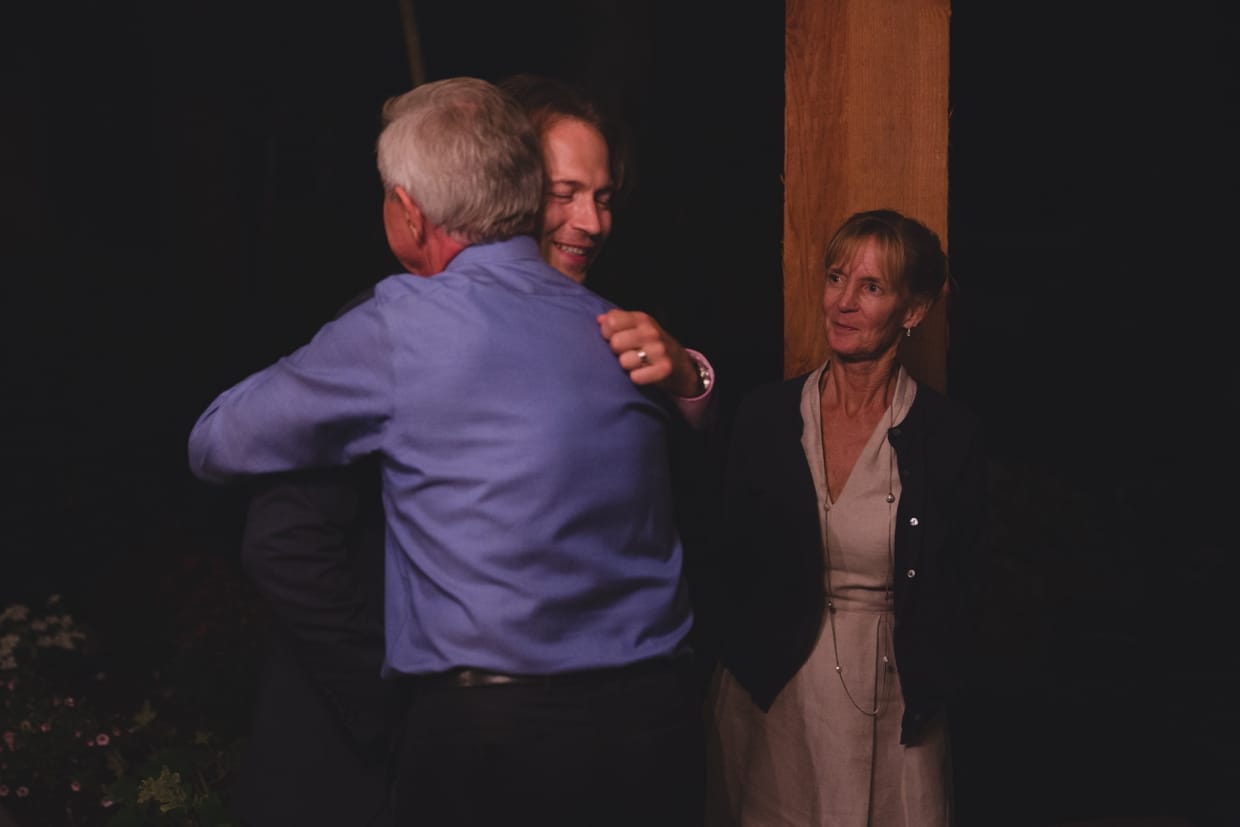 A groom share a special moment with his father at the end of his backyard wedding in Massachusetts