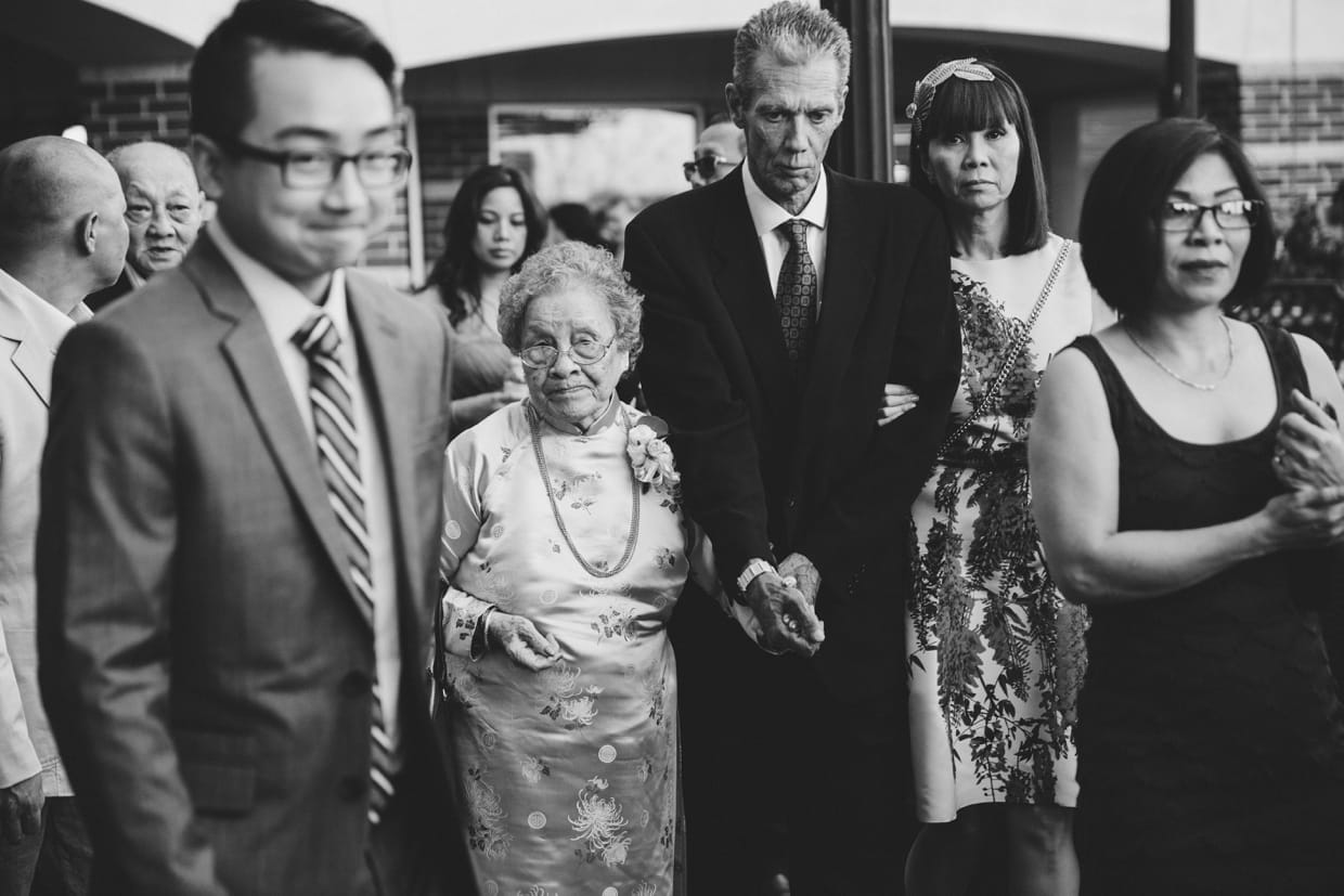 A documentary style photograph of a grandmother walking into the Marriott Hotel during a Boston Wedding