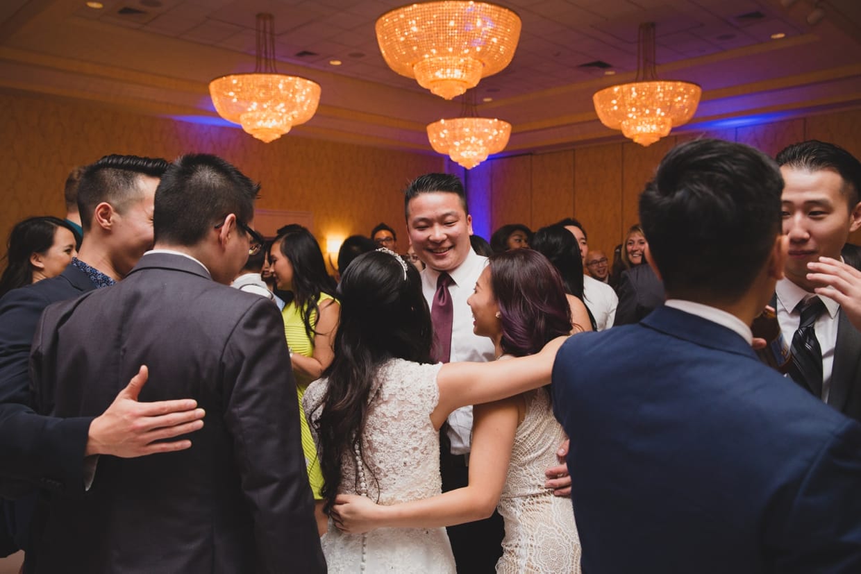 A candid photograph of the bride and groom celebrating with friends during their wedding at the Boston Marriott Hotel