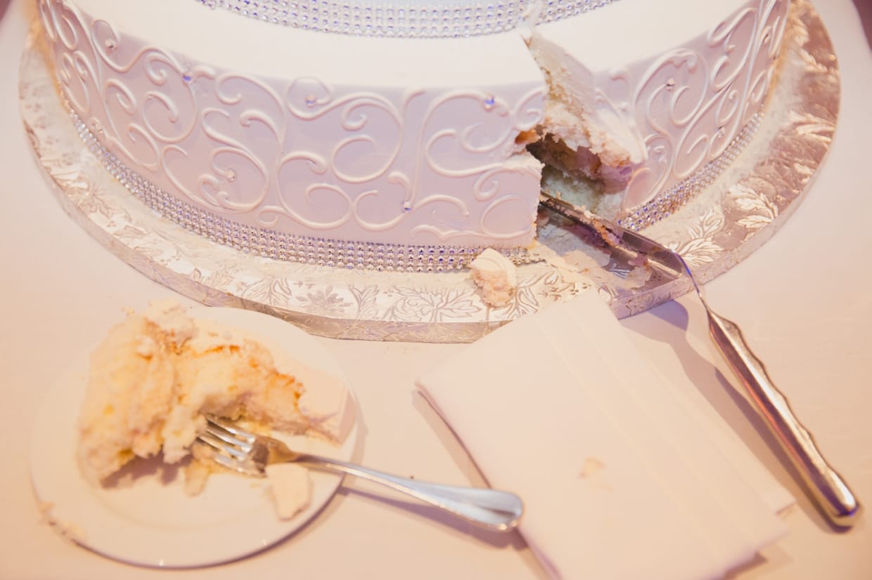 A documentary style photograph of the cutting of the cake during a Boston Marriott Hotel wedding