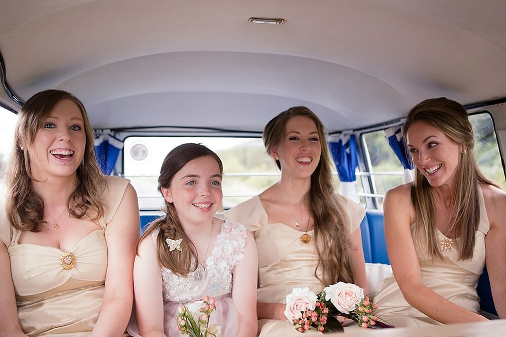 Documentary style photograph of bridesmaids laughing on the way to the wedding ceremony