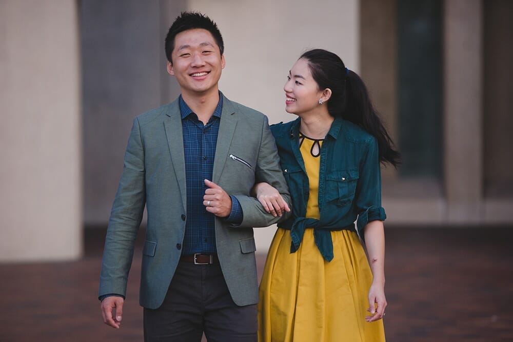 A sweet photograph of a bride and groom walking during their engagement session at the Christian Science Center in Boston, Massachusetts