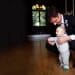A documentary style photograph of a groom playing with a baby at their wedding in Boston, Massachusetts