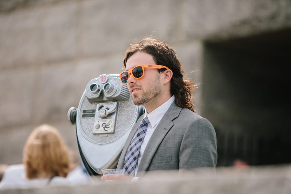A documentary photograph of a wedding guest looking at the view during a wedding at Pilgrims Monument in Provincetown, Cape Cod