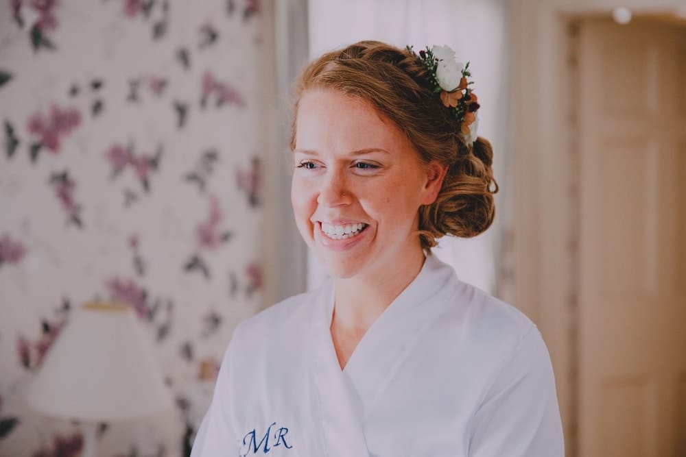 A bride smiles as she gets ready for her rustic barn wedding at Kitz Farm in New Hampshire