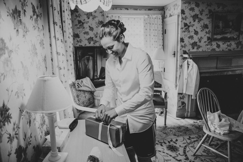 A bride opens a gift from her bride at the Governors Inn before her Kitz Farm wedding in New Hampshire