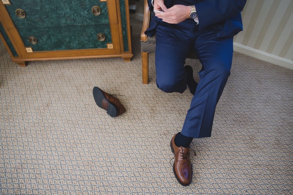 A photojournalistic photograph of a groom getting ready at the Langham Hotel before his wedding at the State Room in Boston, Massachusetts