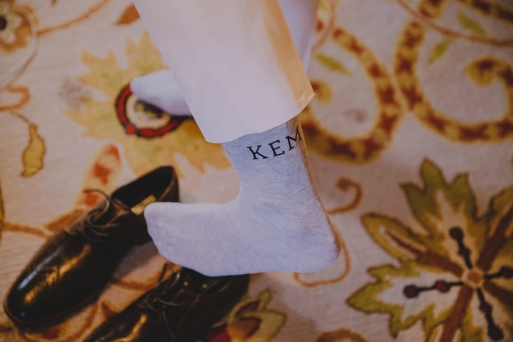 An artistic photograph of bride putting on her wedding shoes before her rustic barn wedding at Kitz Farm in New Hampshire