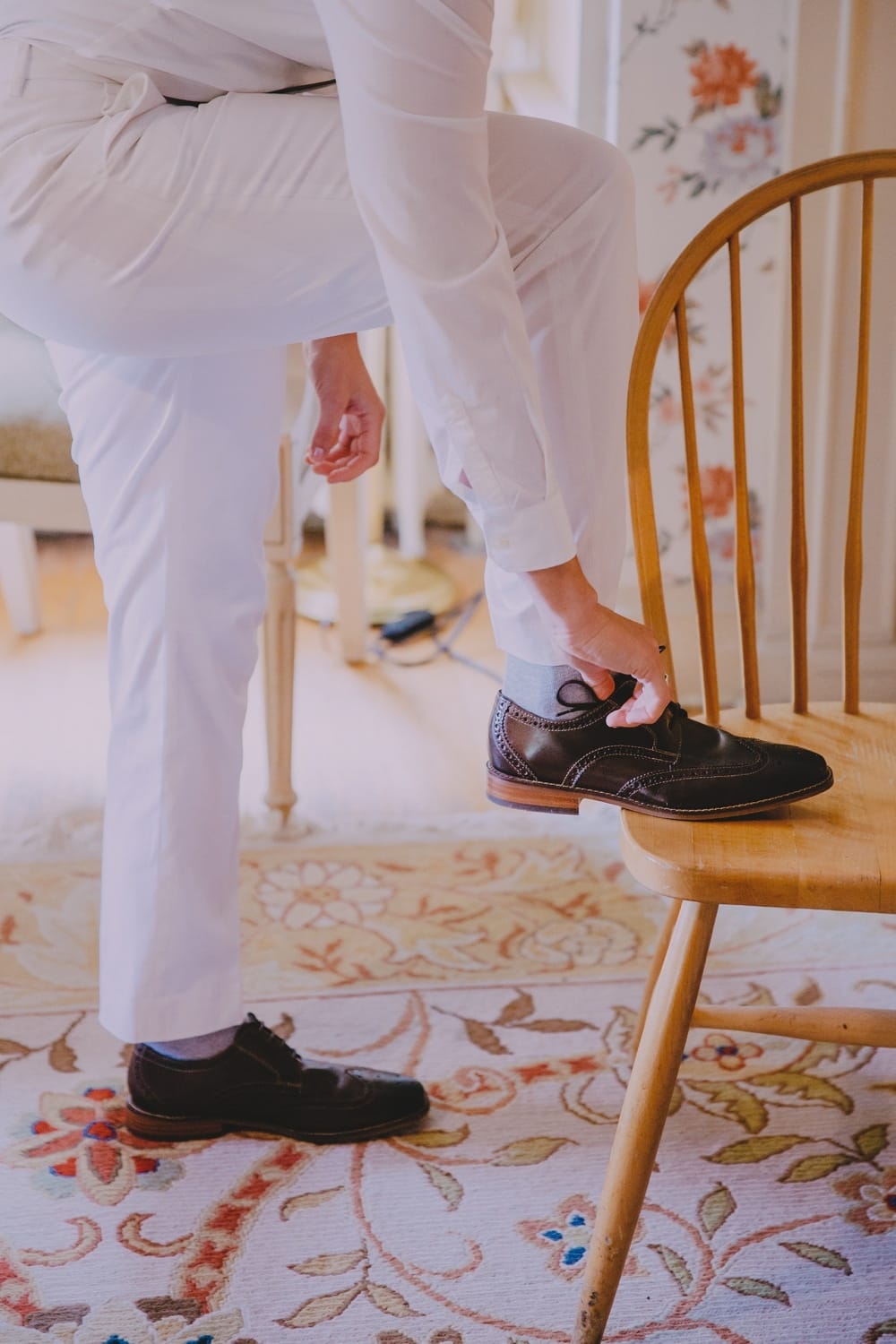 A photojournalistic photograph of a bride putting on her wedding shoes at the Governors Inn before her rustic barn wedding at Kitz Farm in New Hampshire