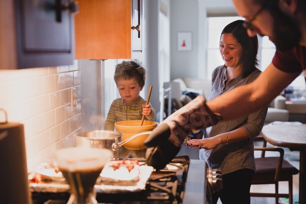 A documentary photograph of a family making breakfast during their in home family session in Boston, Massachusetts