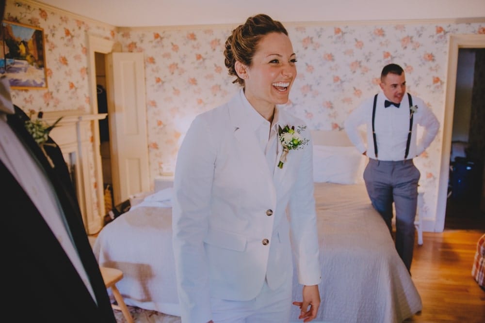 A bride laughs while getting ready for her rustic New Hampshire barn wedding at Kitz Farm