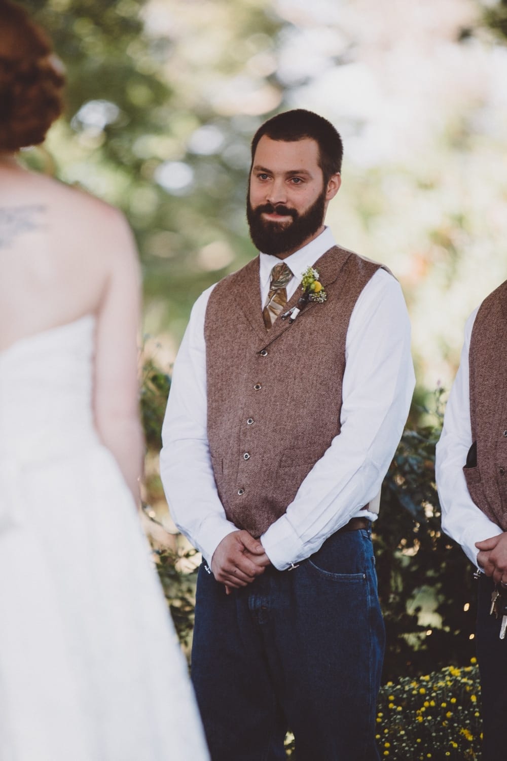 A documentary photograph of a groom watching his bride walk up the aisle during their rustic River Club Wedding in Scituate, Massachusetts