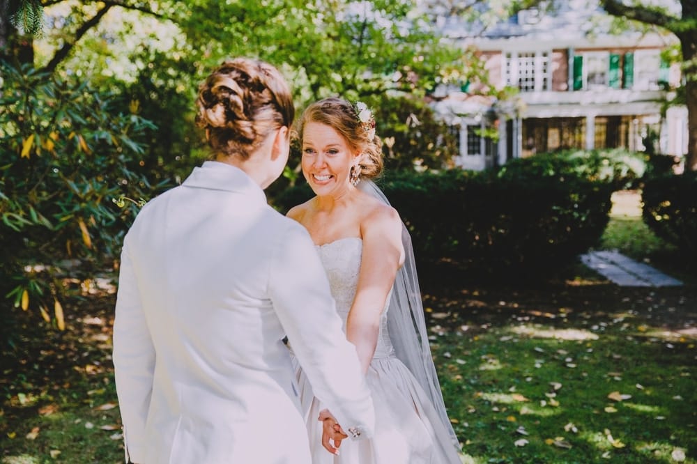 An emotional photojournalistic photograph of two brides having a first look before their rustic barn wedding at Kitz Farm in New Hampshire