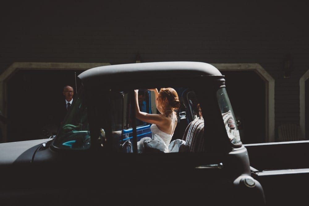 A documentary photograph of a bride getting into her truck before leaving for her wedding at the River Club in Massachusetts