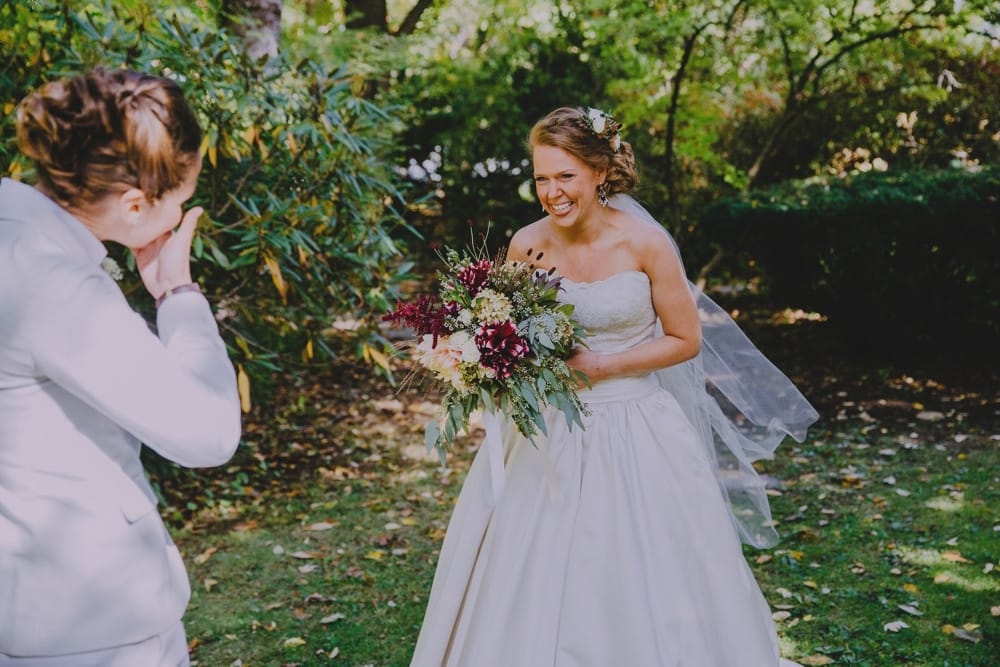 A documentary photograph of two brides having their first look at the Governors Inn before their wedding at Kitz Farm in New Hampshire