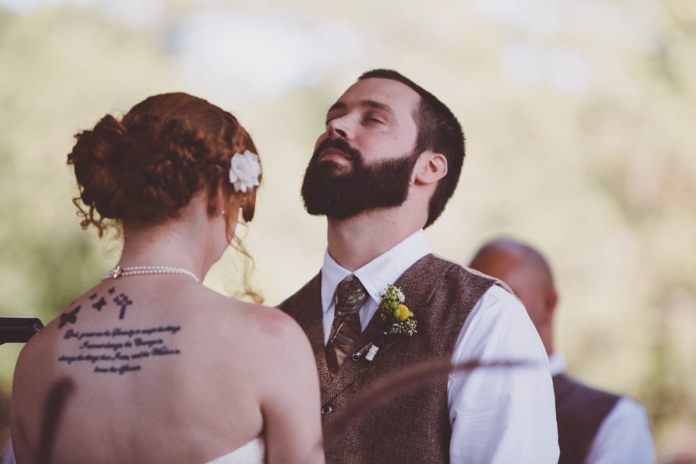 An emotional documentary photograph of a groom during an intimate and rustic outdoor River Club Wedding ceremony in Scituate, Massachusetts