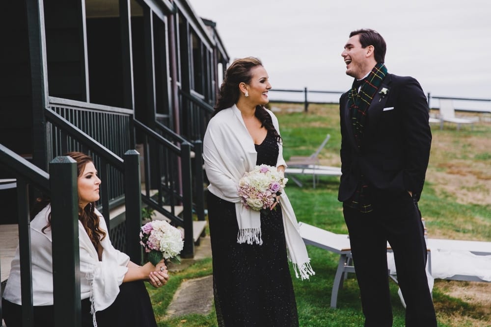 A photojournalistic photograph of wedding guests laughing during a wedding reception at the Castle Hill Inn in Newport, Rhode Island