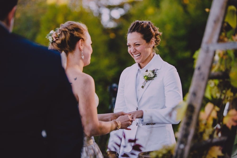 A documentary photograph of two brides saying their vows during their wedding ceremony at Kitz Farm in New Hampshire