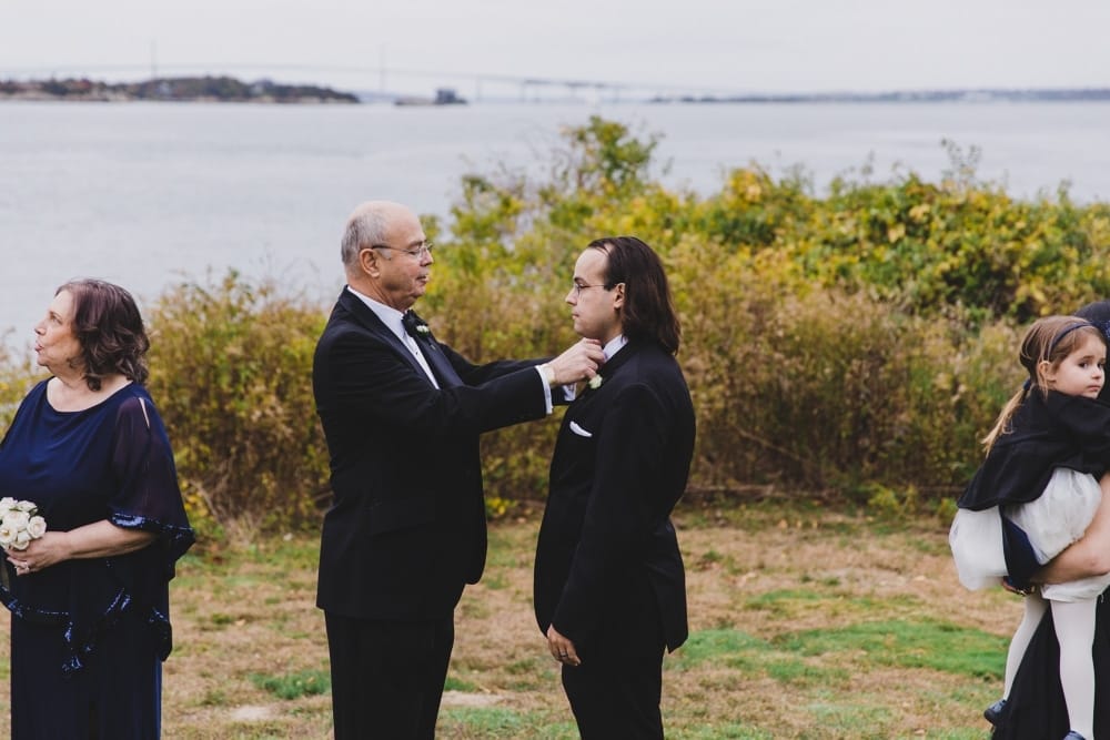 A documentary photograph of a father fixing his son's bow tie during a wedding reception at the Castle Hill Inn in Newport, Rhode Island