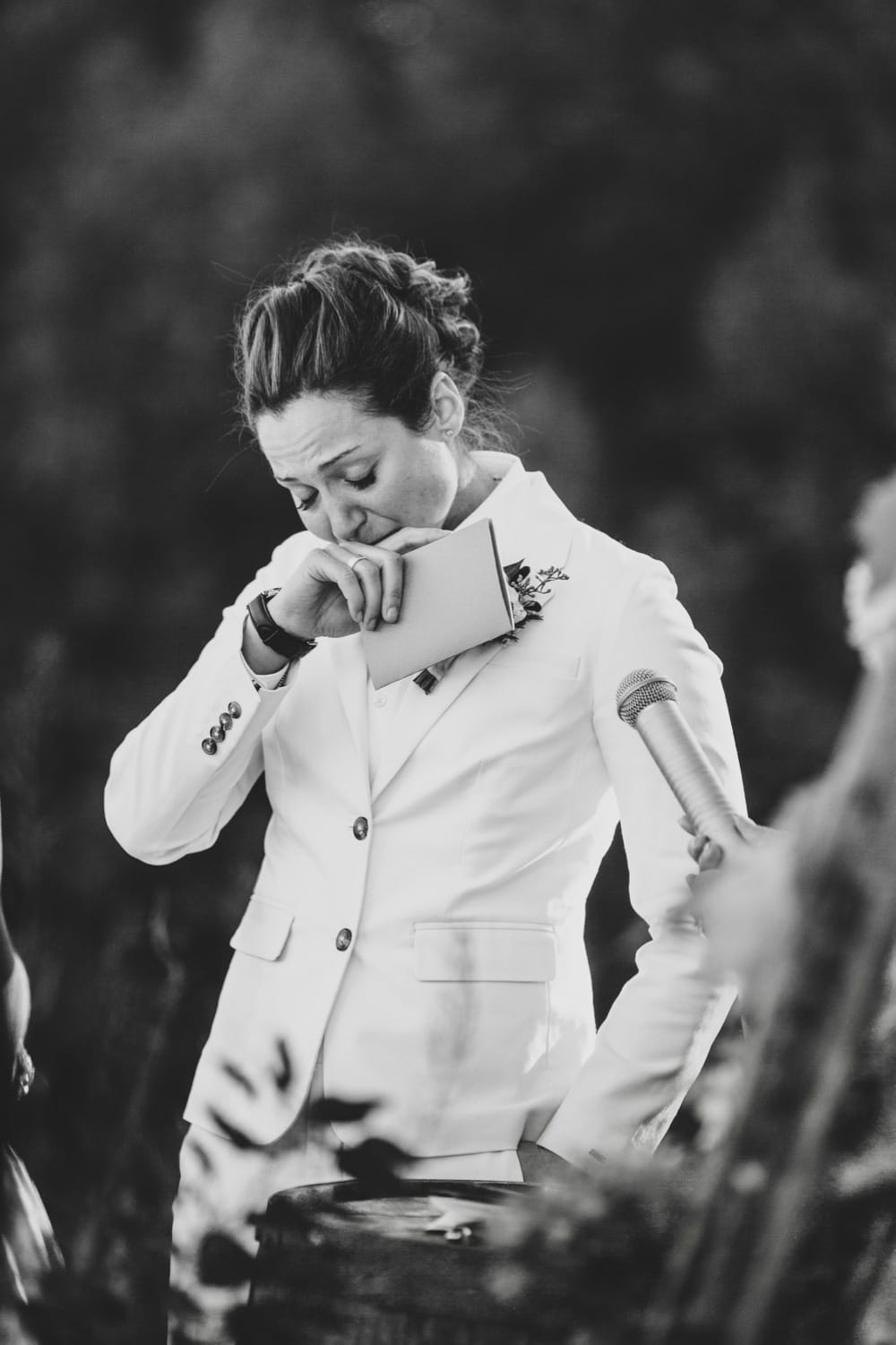 A beautiful and emotional documentary photograph of a bride crying as she reads her vows to her bride during their rustic outdoor wedding ceremony at Kitz Farm in New Hampshire