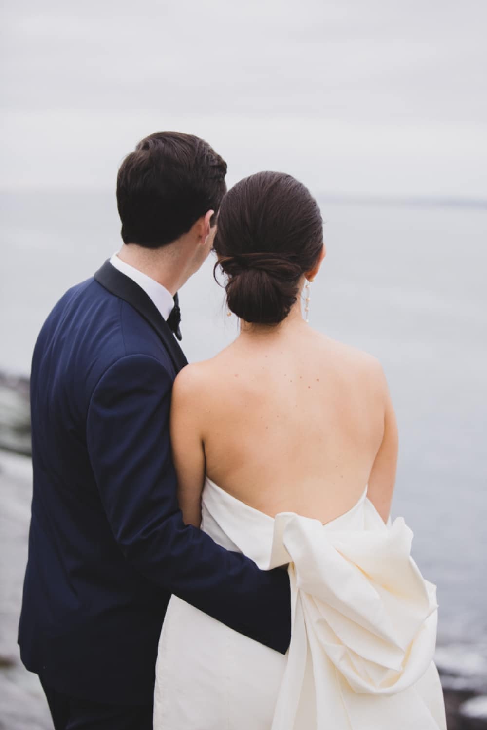 A beautiful portrait of a bride and groom look out into the ocean during their Castle Hill Inn Wedding in Newport, Rhode Island