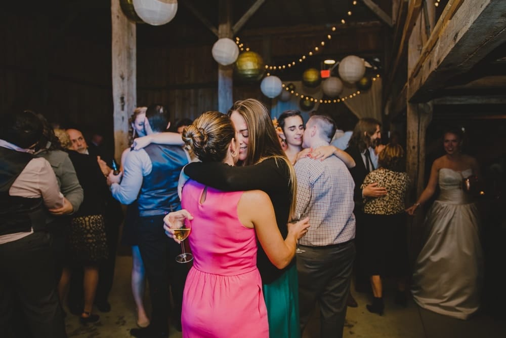 A photojournalistic photograph of wedding guests dancing during a rustic DIY barn wedding at Kitz Farm in New Hampshire